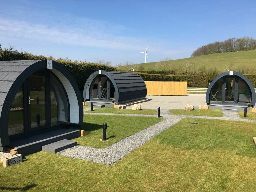 Three camping pods with pathway and grass at Pod 4 (No Pets) Carnforth