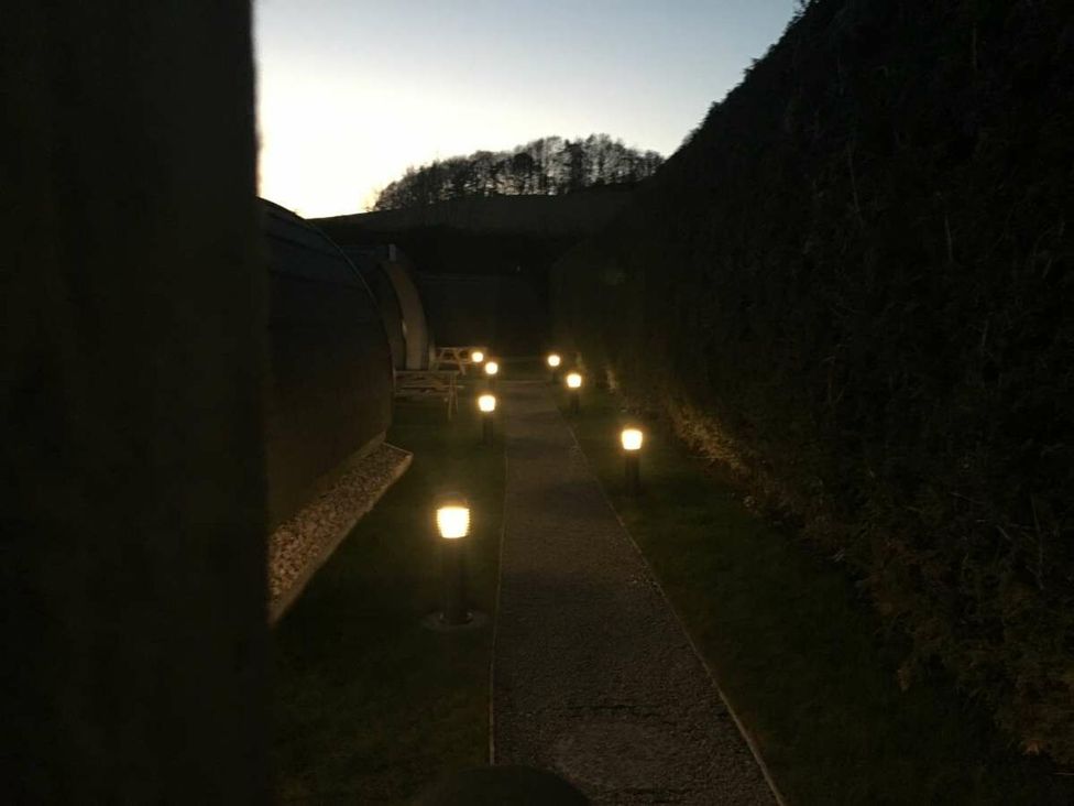 A pathway with lights alongside hedges at Pod 4 (No Pets) in Carnforth