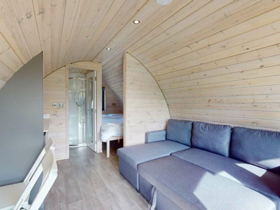 A living room with a sofa and shower at Pod 6 (No Pets) in Carnforth