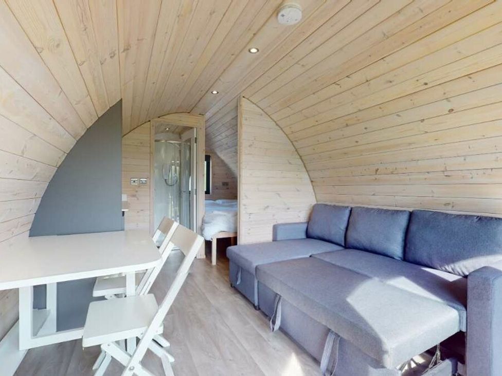 A living room with a sofa and table at Pod 6 (No Pets) in Carnforth