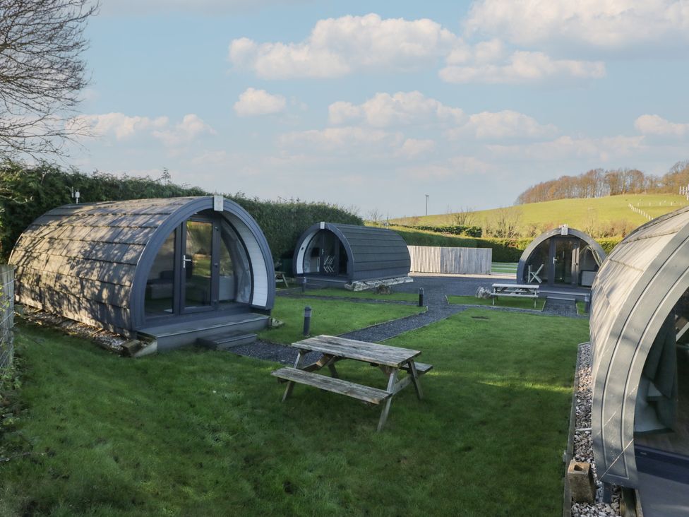 Pods in a garden area with a picnic table at Pod 6 (No Pets) in Tewitfield