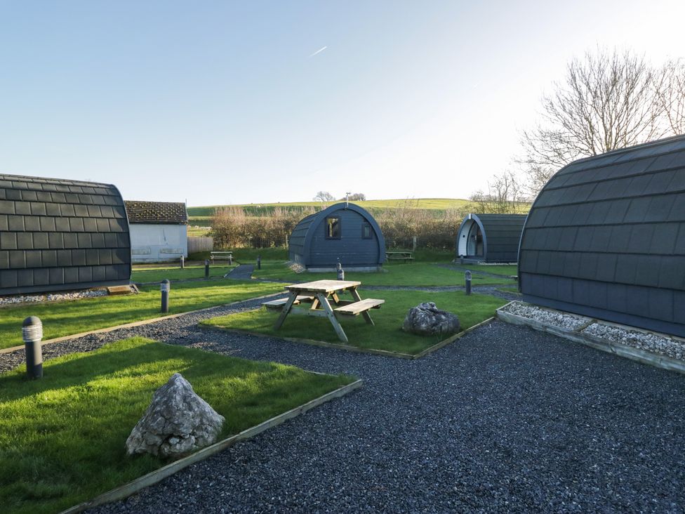 An outdoor area with cabins and a picnic table at Pod 7 (Pet Friendly) Tewitfield