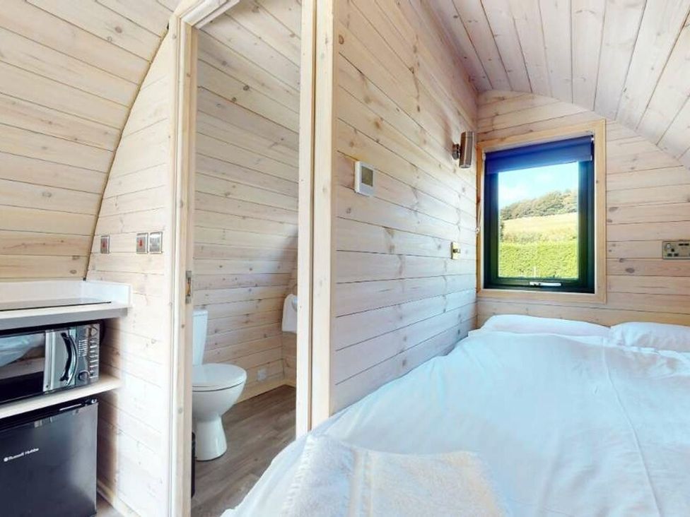 A bedroom with a bed, microwave, and a toilet at Pod 9 (No Pets) Carnforth