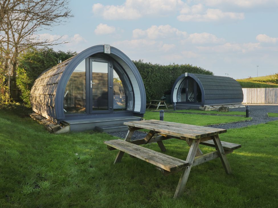 Two camping pods with a picnic table in front at Pod 9 (No Pets) Tewitfield near Carnforth