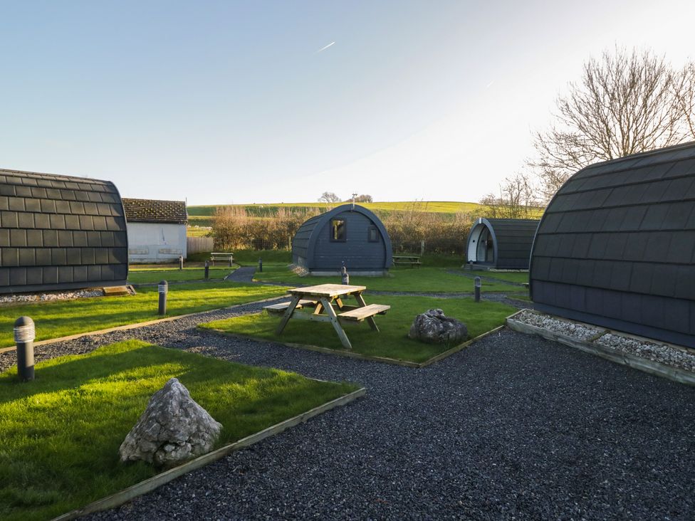 An outdoor area with cabins and a picnic table at Pod 9 (No Pets) Tewitfield near Carnforth