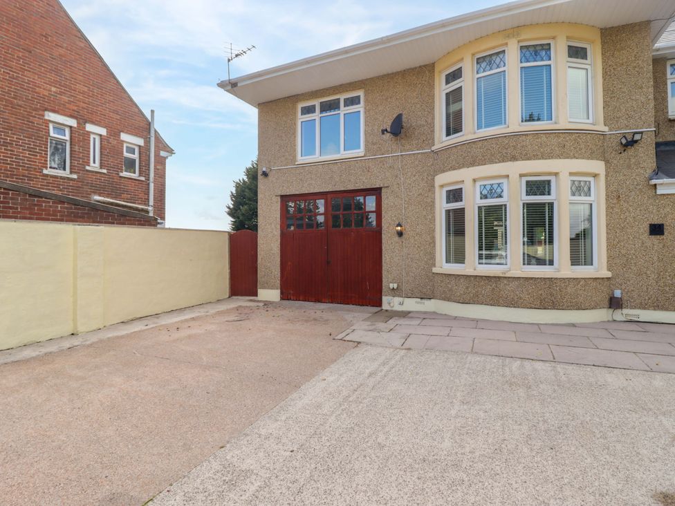 An outdoor area with a house featuring a garage door at William's Place in Barry