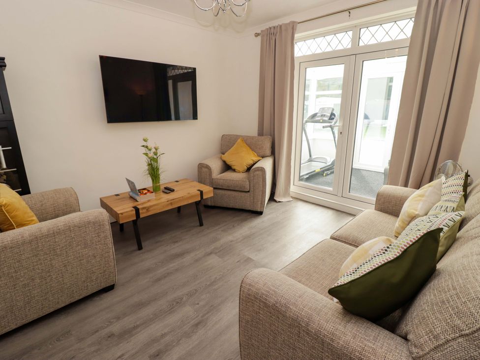 A living room with sofas and a television at William's Place in Barry