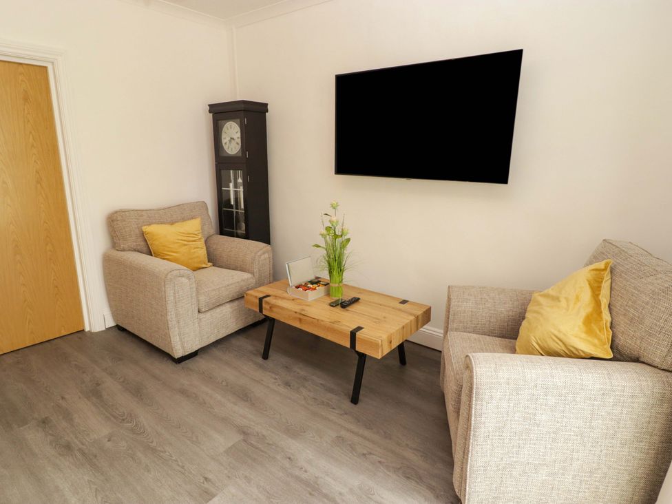 A living room with armchairs and a coffee table at William's Place in Barry