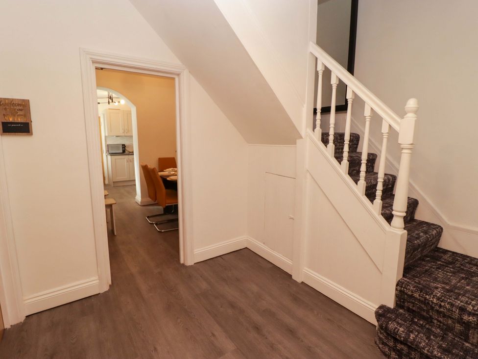 A hallway with a staircase and doorway to a dining area at William's Place in Barry