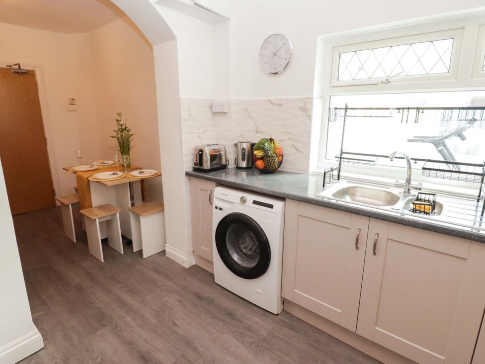 A kitchen with a washing machine and sink at William's Place in Barry