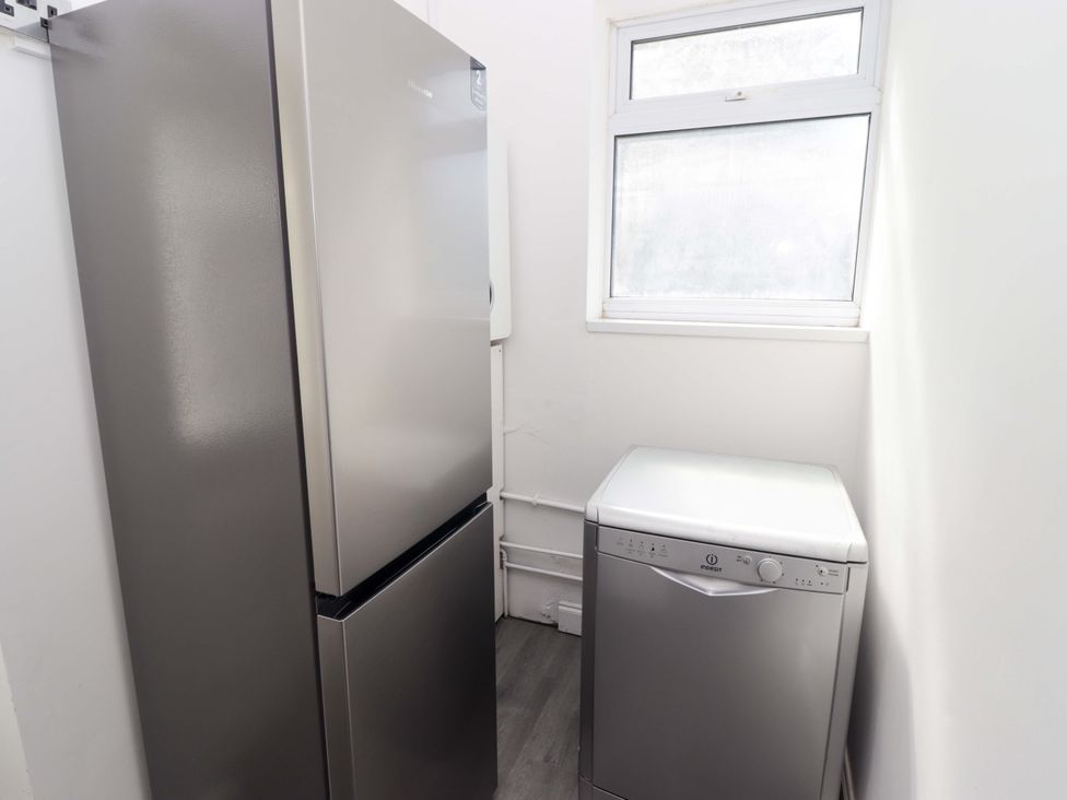 A utility room with a refrigerator and dishwasher at William's Place in Barry