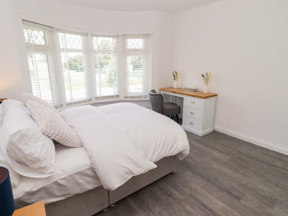 A bedroom with a bed and a desk at William's Place in Barry