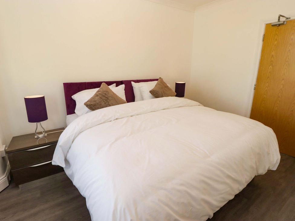 A bedroom with a bed and bedside lamps at William's Place in Barry