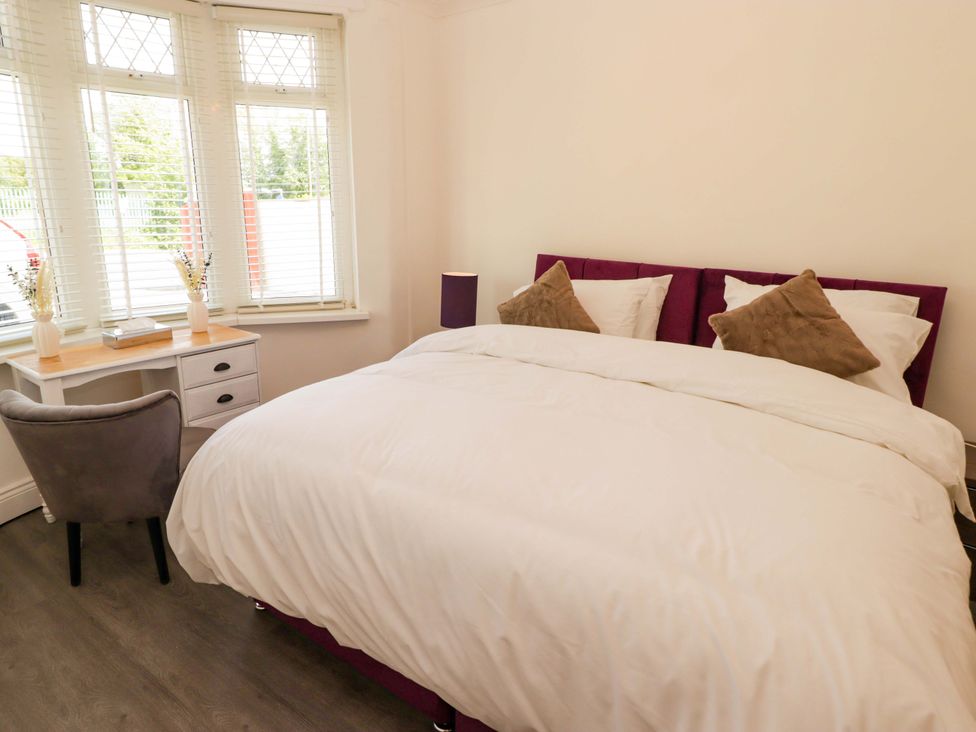 A bedroom with a bed and a desk at William's Place in Barry