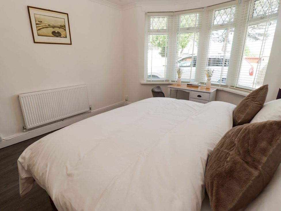 A bedroom with a bed, desk, and radiator at William's Place in Barry