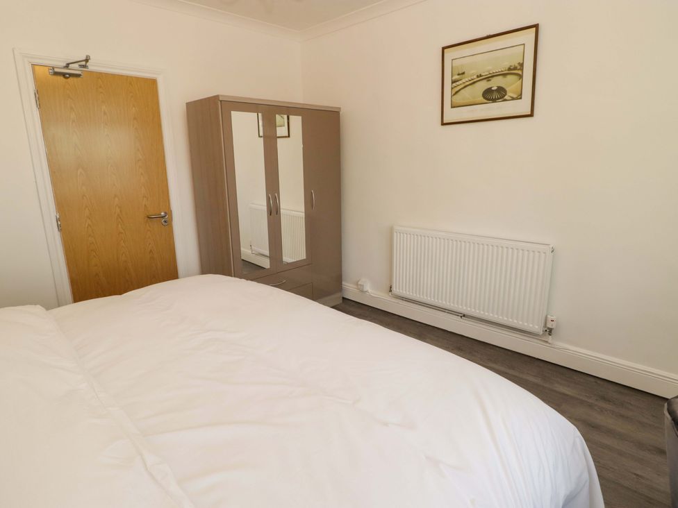 A bedroom with a wardrobe and a radiator at William's Place in Barry