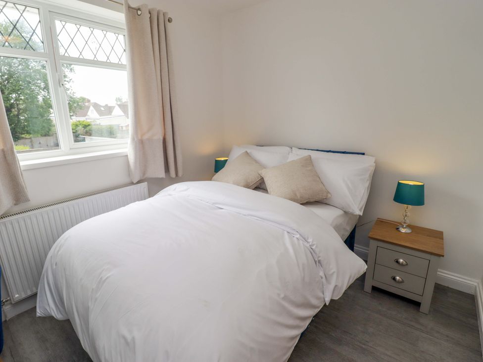 A bedroom with a bed and bedside table at William's Place in Barry