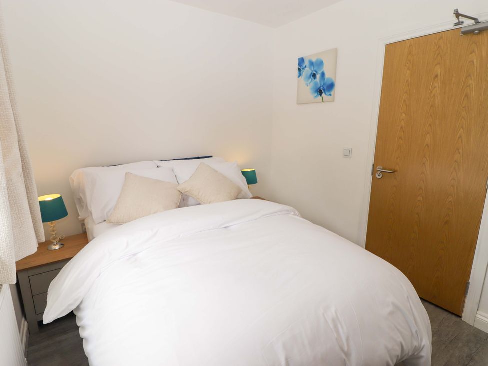 A bedroom with a bed and bedside table at William's Place in Barry