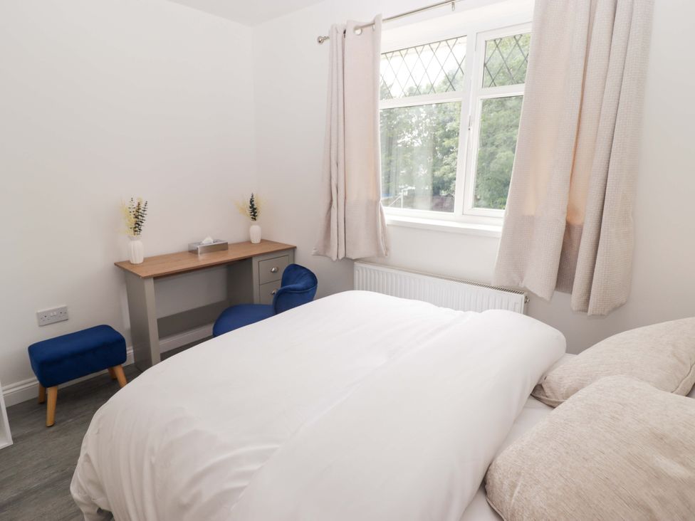 A bedroom with a bed and desk at William's Place in Barry
