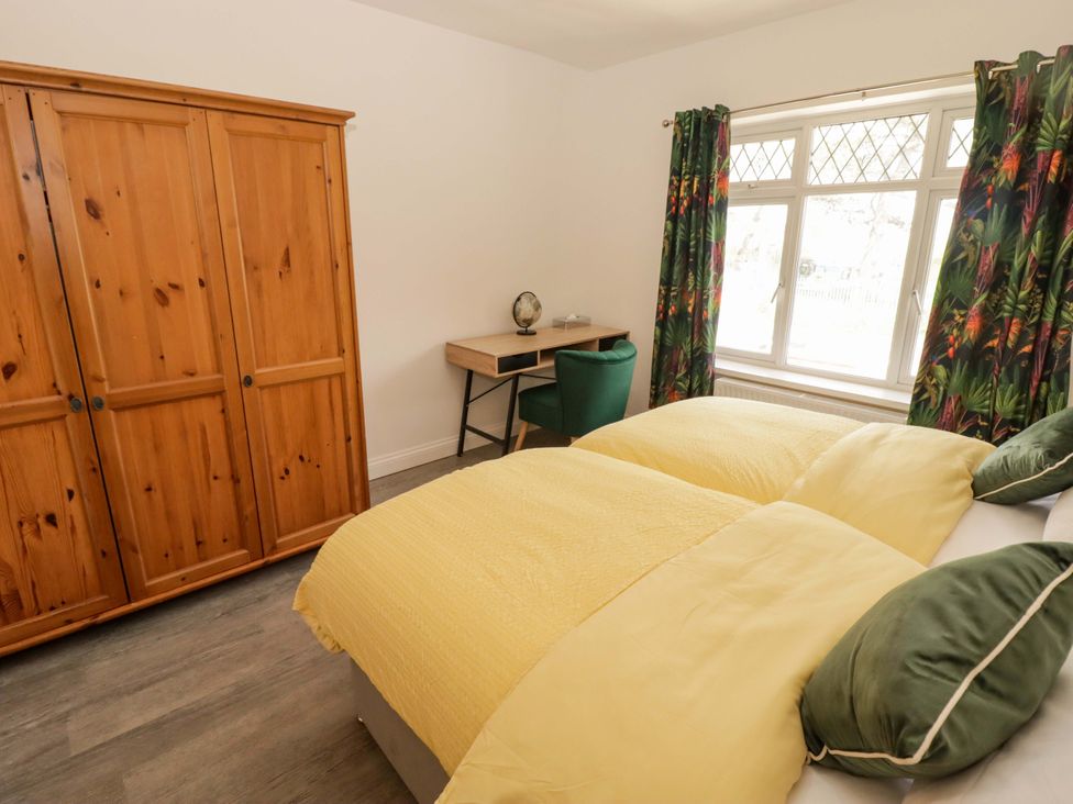 A bedroom with a bed and desk at William's Place in Barry