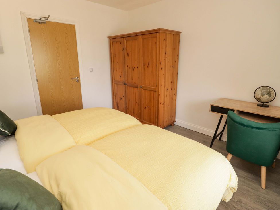 A bedroom with a bed and wardrobe at William's Place in Barry