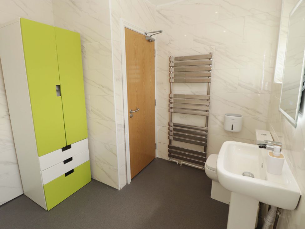 A bathroom with a sink and cabinet at William's Place in Barry