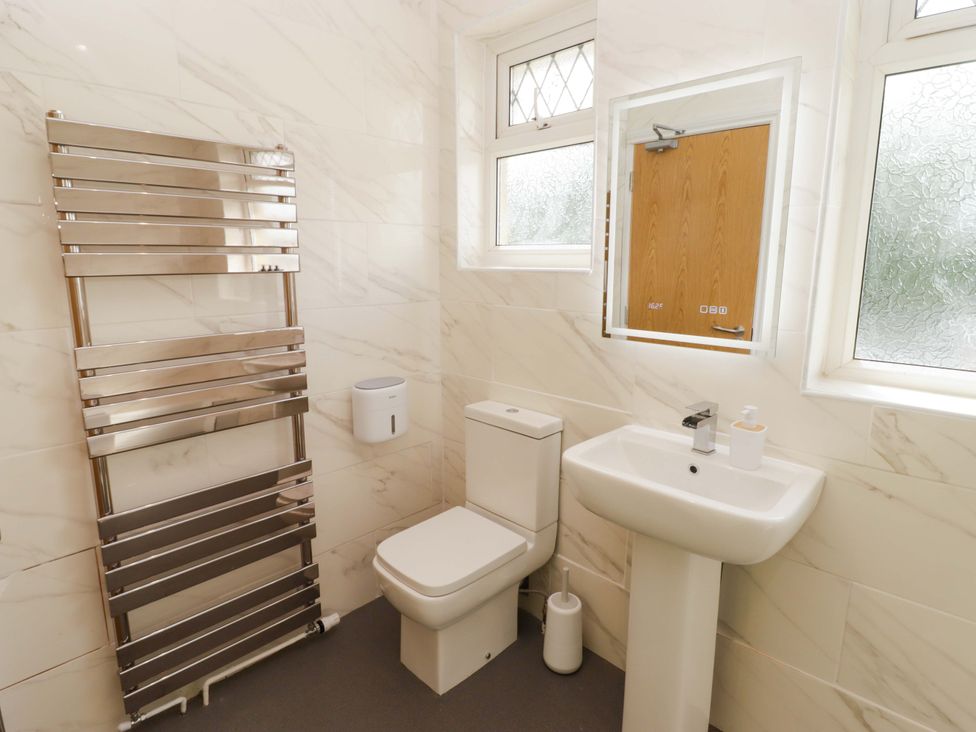 A bathroom with a towel rail, toilet, and sink at William's Place in Barry