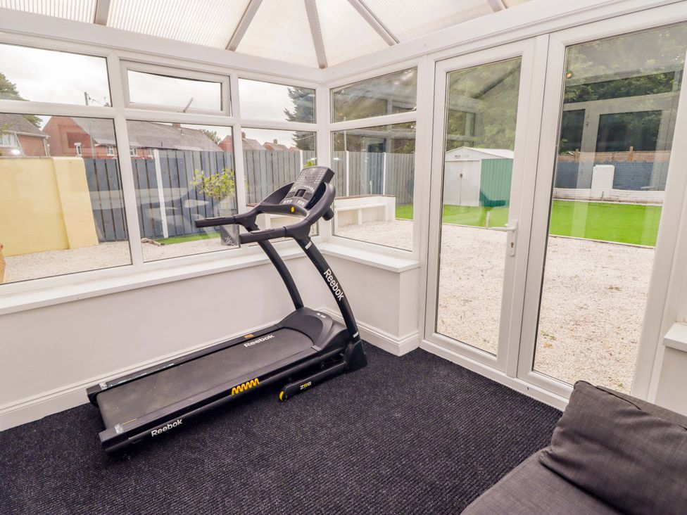 A conservatory with a treadmill and windows at William's Place in Barry