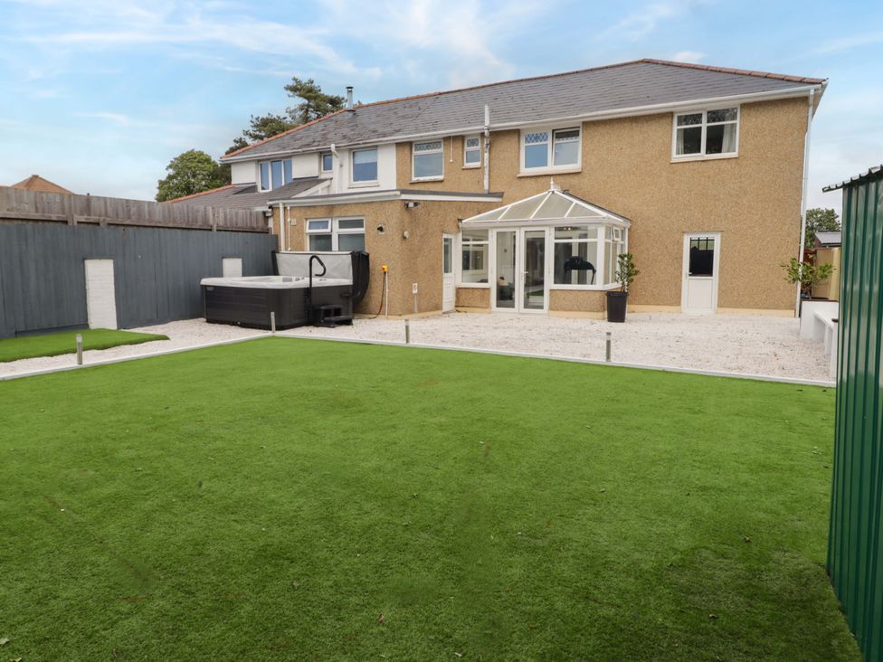A garden with spa and artificial grass at William's Place in Barry