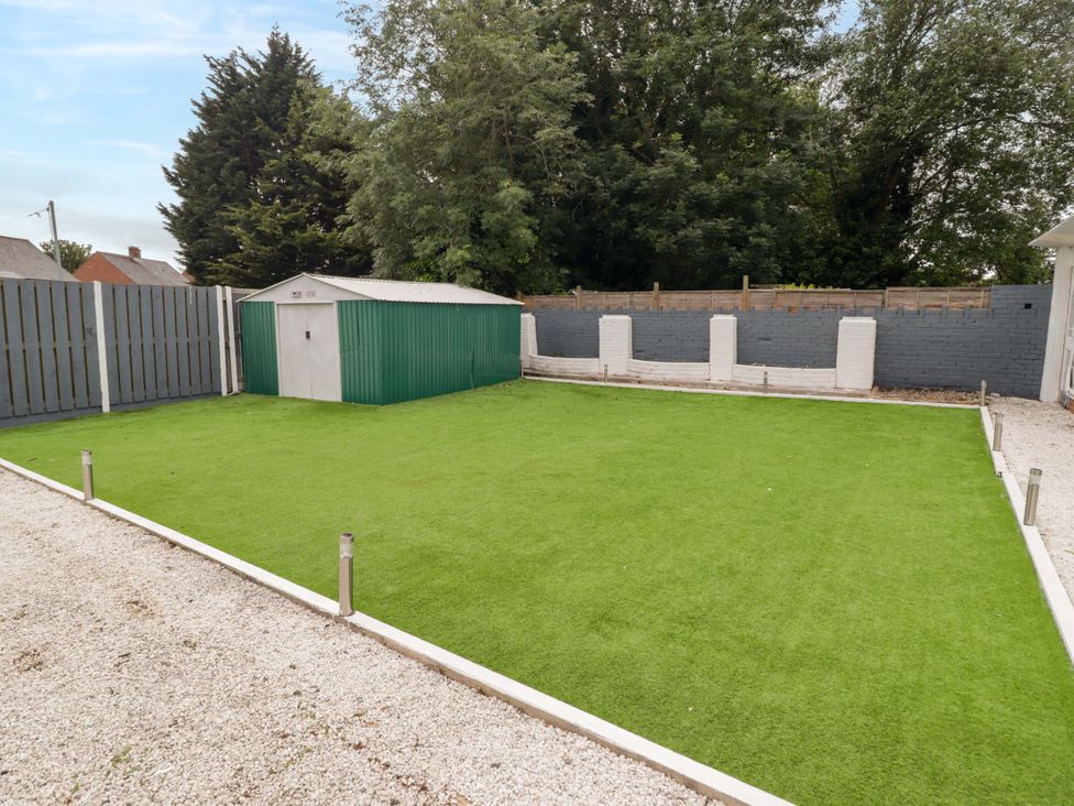 A garden with artificial grass and a shed at William's Place in Barry