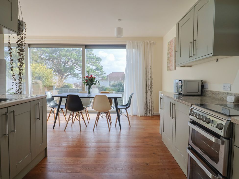 A kitchen with a dining table and chairs at Fluta in Seaton