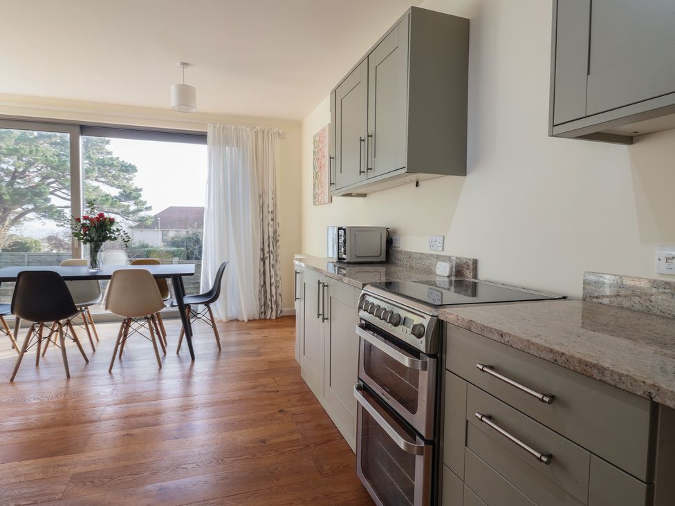 A kitchen with a stove and table at Fluta in Seaton