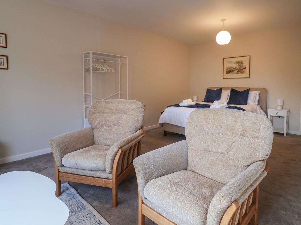 A bedroom with armchairs and a bed at Fluta in Seaton