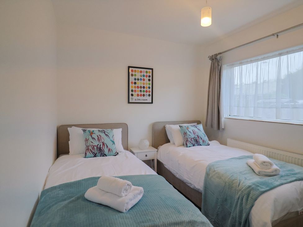 A bedroom with two beds and wall art at Fluta in Seaton