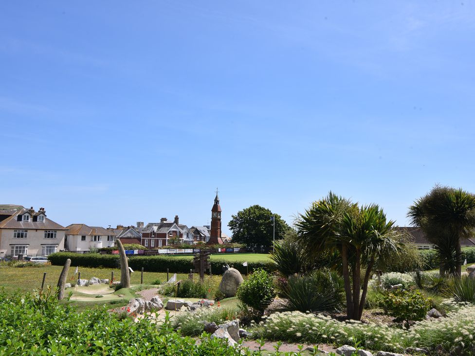 A park with grass and trees near buildings at Fluta in Seaton