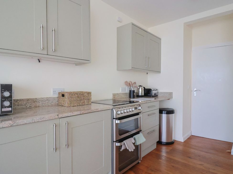 A kitchen with appliances and cabinets at Fluta in Seaton