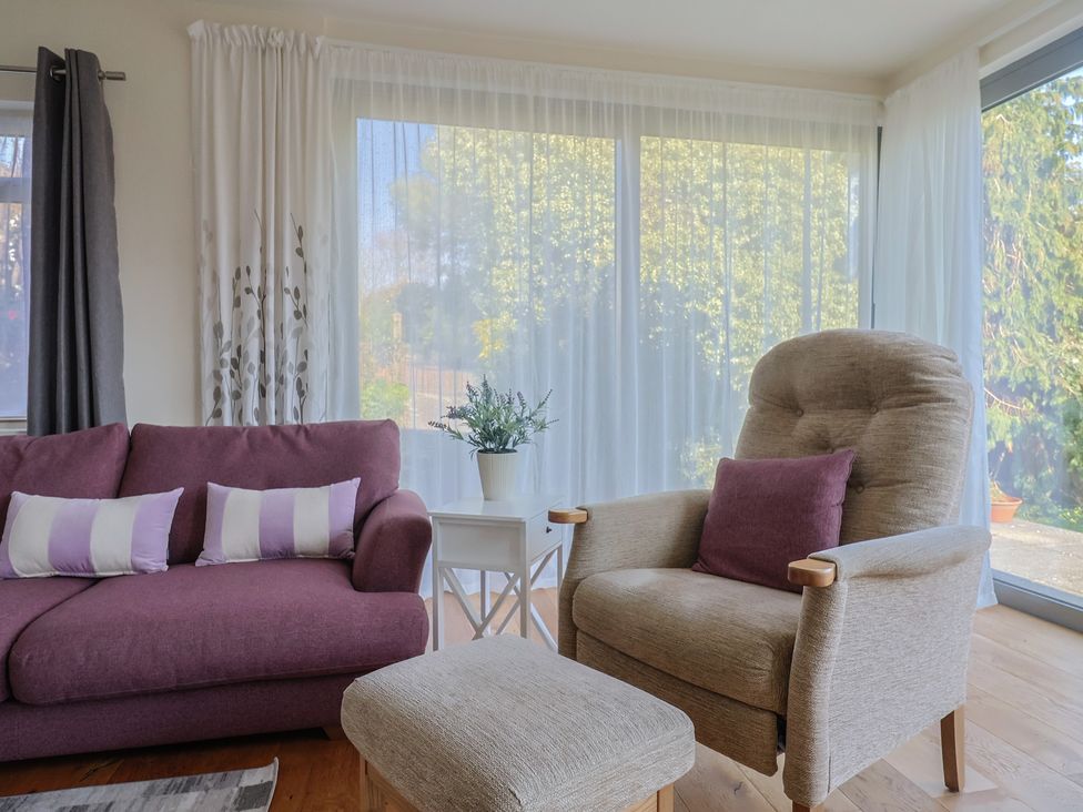 A living room with a sofa, chair, and plant at Fluta in Seaton