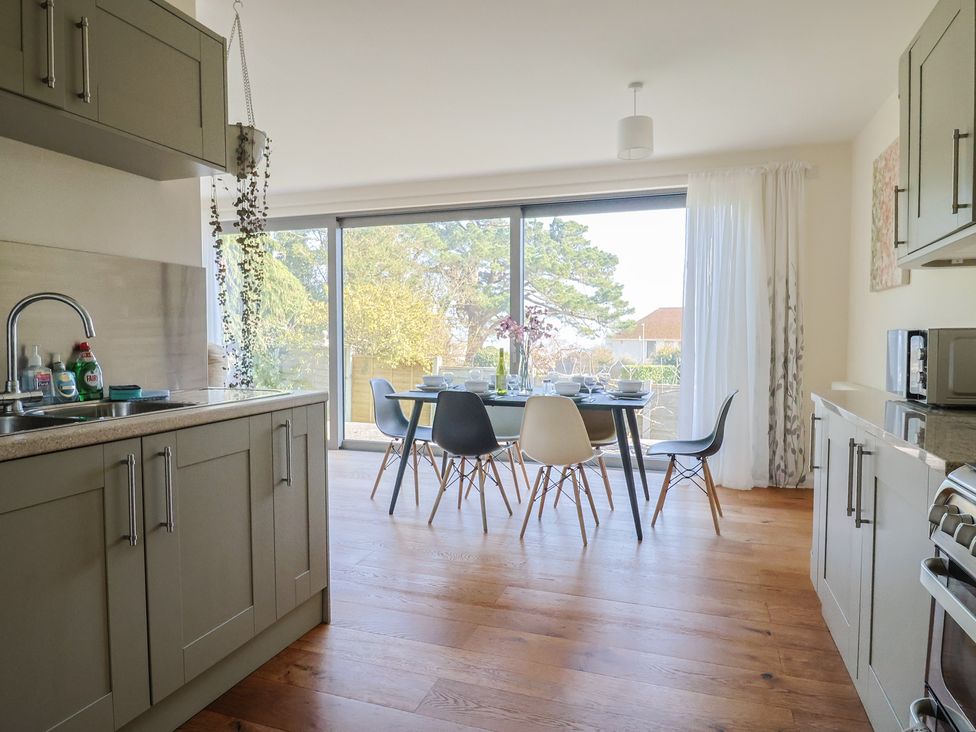 A kitchen with a dining area and glass doors at Fluta in Seaton