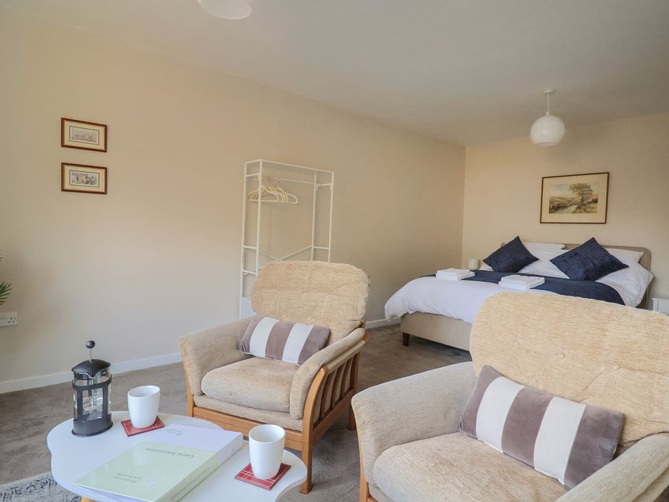 A bedroom with a bed and seating area at Fluta in Seaton