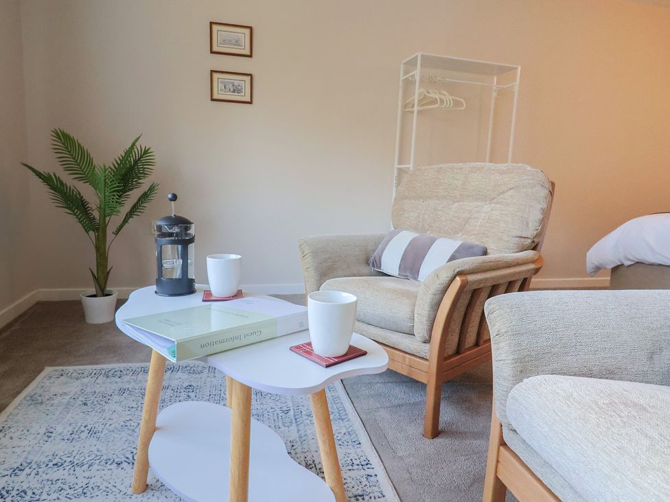 A living room with an armchair and a coffee table at Fluta in Seaton