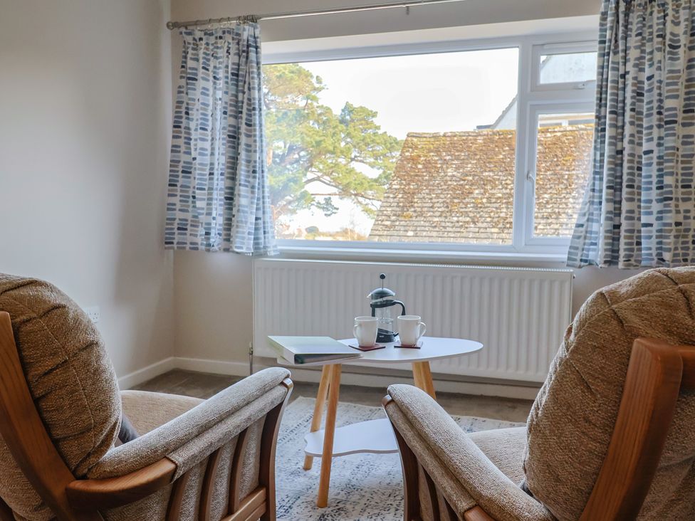 A living room with two chairs and a table at Fluta in Seaton