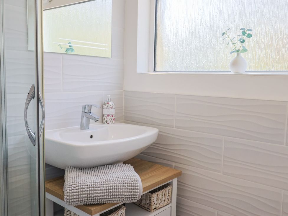 A bathroom with a sink and shower at Fluta in Seaton