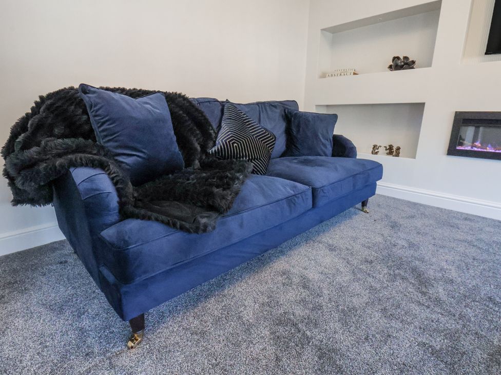 A sofa with pillows and a blanket in a living room at 2 bed Scarborough