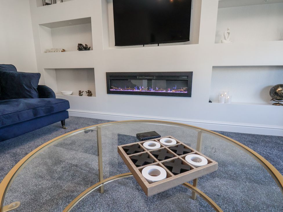 A living room with a sofa, coffee table and television in 2 bed Scarborough