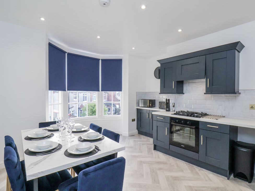 A kitchen with a dining area and modern appliances at 2 bed Scarborough