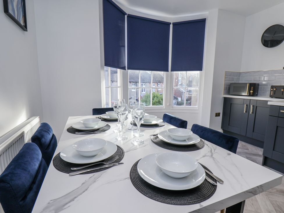 A dining room with a table set for dinner at 2 bed in Scarborough