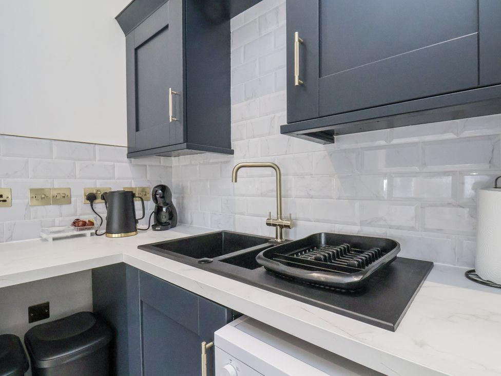 A kitchen with a sink, kettle, and coffee maker at 2 bed in Scarborough