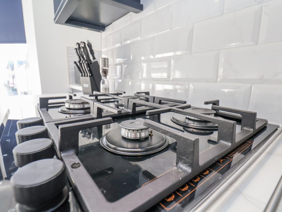 A gas stove with knobs and kitchen utensils at 2 bed in Scarborough