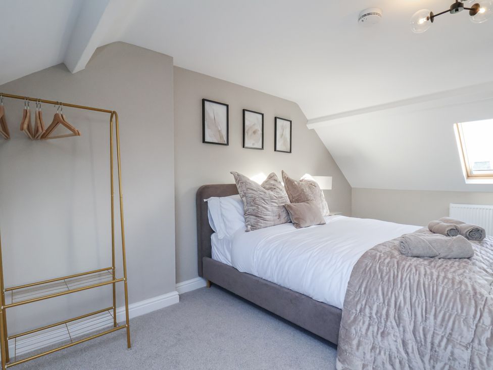 A bedroom with a bed and clothes rack at 2 bed in Scarborough
