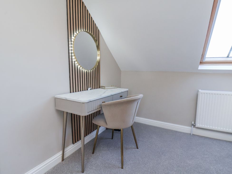 A dressing area with a vanity table and mirror at 2 bed in Scarborough
